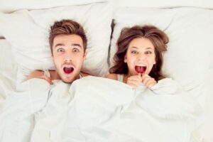 couple dans un lit avec un air choqué éjaculation précoce homme cause périnée  