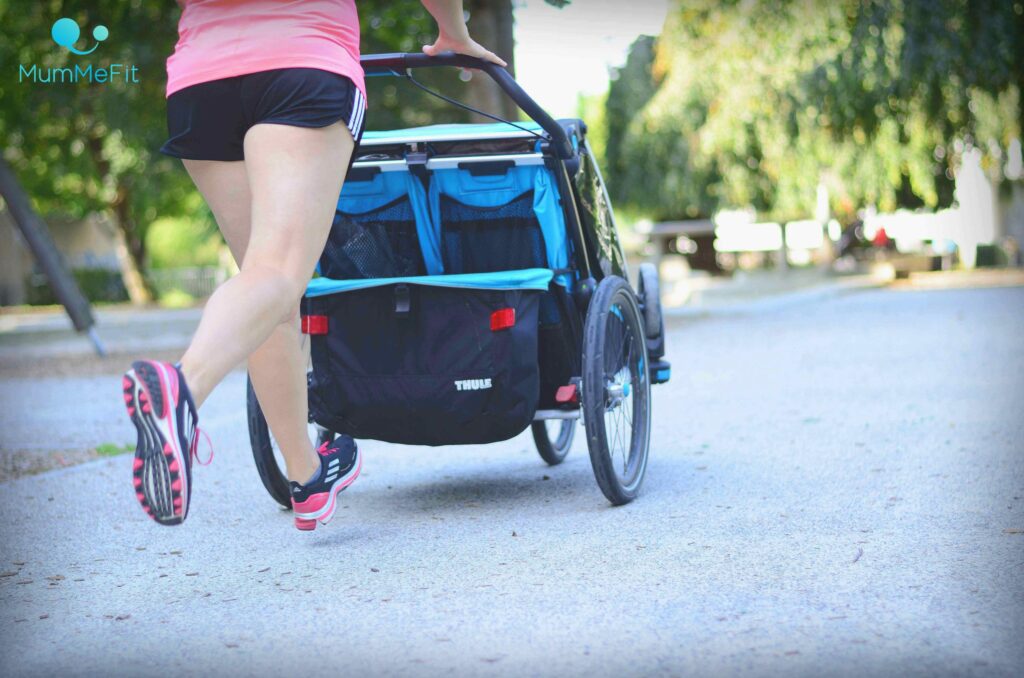 Mama bem Joggen mit Kind und Kinderwagen