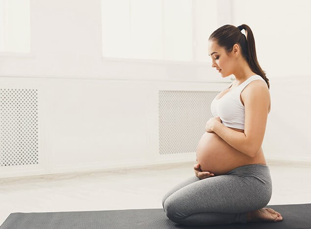 femme enceinte sur tapis de sport tonification du périnée grossesse 