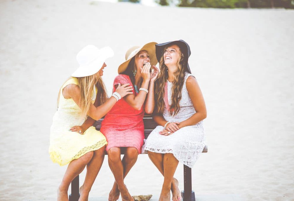 Freundinnen reden und lachen zusammen am Strand
