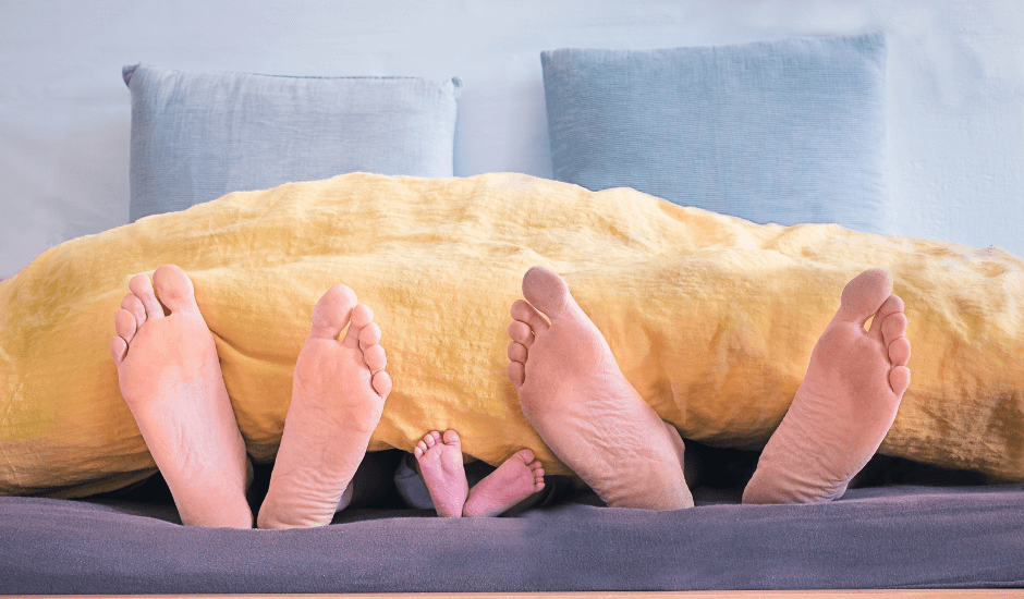 famille dans un lit avec les pieds qui dépassent du lit 