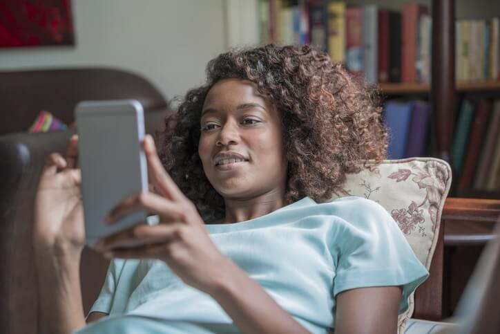 femme qui regarde son téléphone , problème d'incontinence solution Emy by fizimed