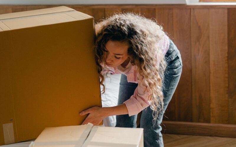 Femme qui porte une boîte lourde