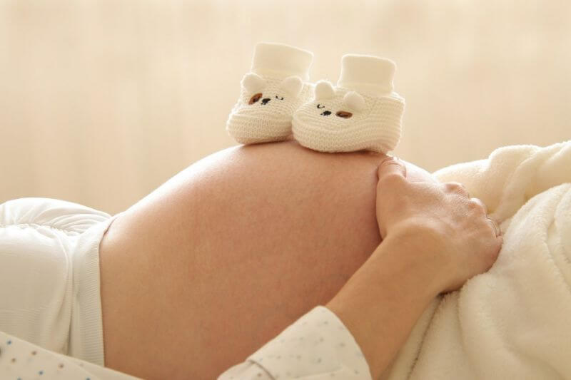 femme enceinte avec chausson sur le ventre
