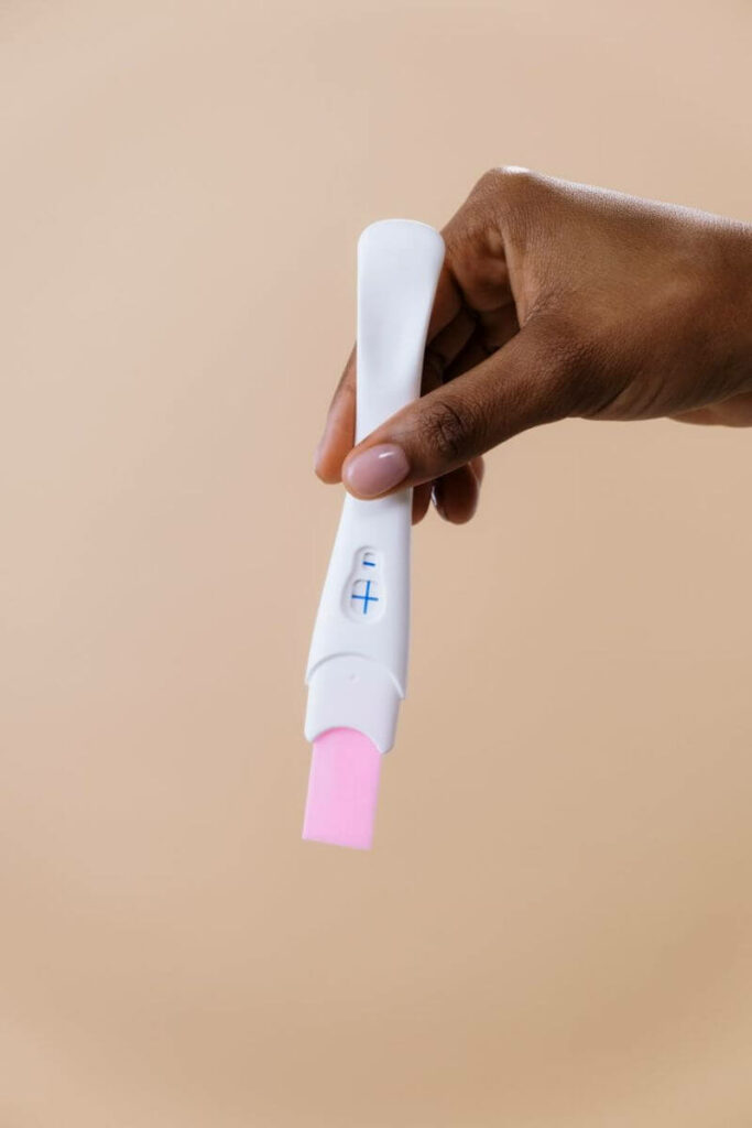 femme qui tient un test de grossesse dans sa main
