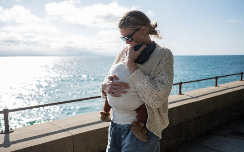 femme qui porte son bébé et adapte sa posture