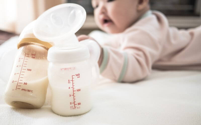 baby drinking breast milk from a bottle